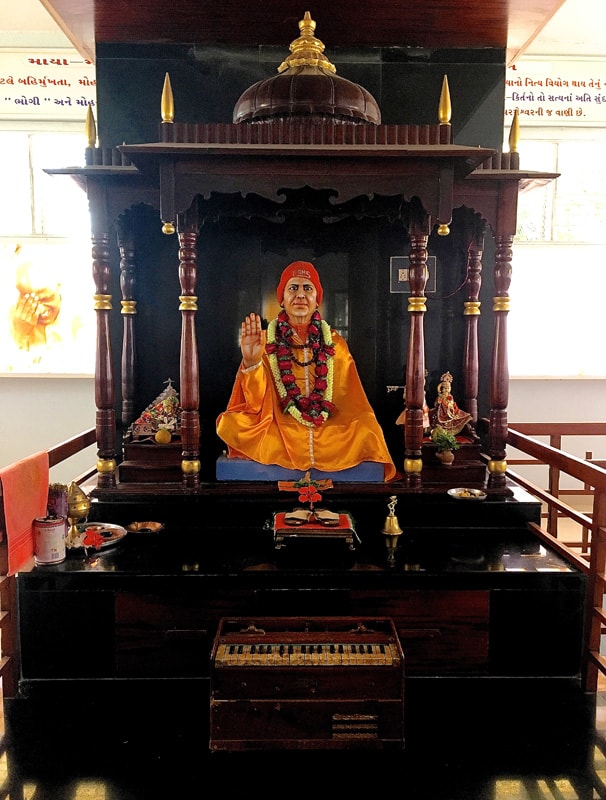 The Murti of Swami Kripalvananda (Swami Kripalu) in Ulka, his former residence in Kayavarohan. Also shown are his shoes and harmonium.
